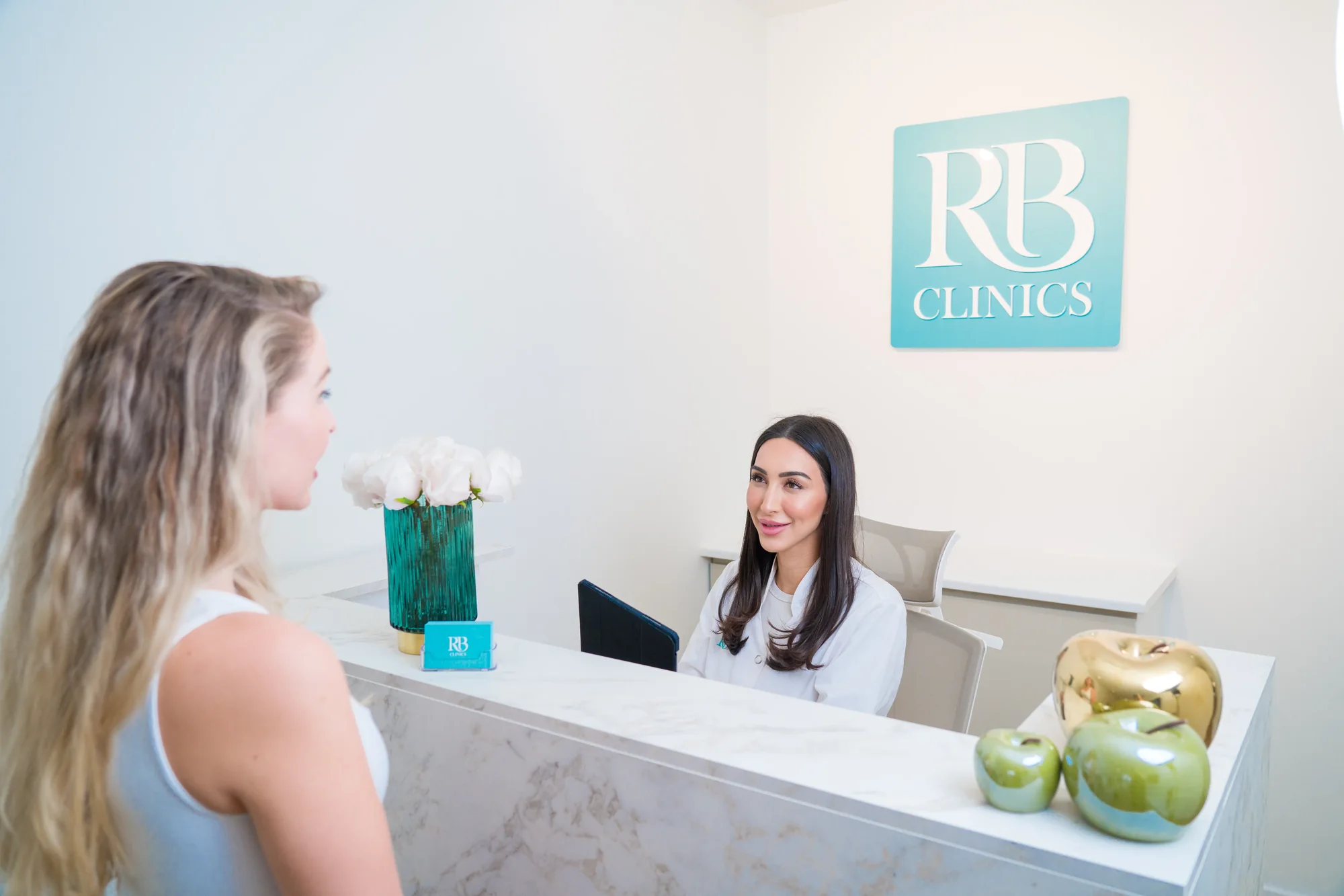Client wordt ontvangen bij de receptie van RB Clinics Amsterdam