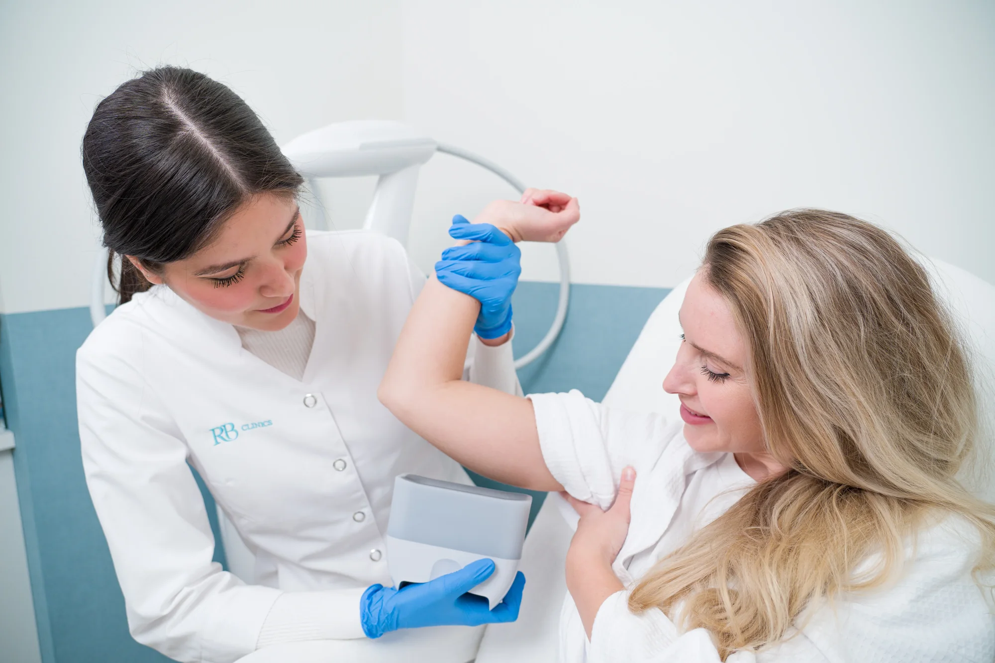 Specialist behandelt de bovenarm met een behandelkop voor vet bevriezen